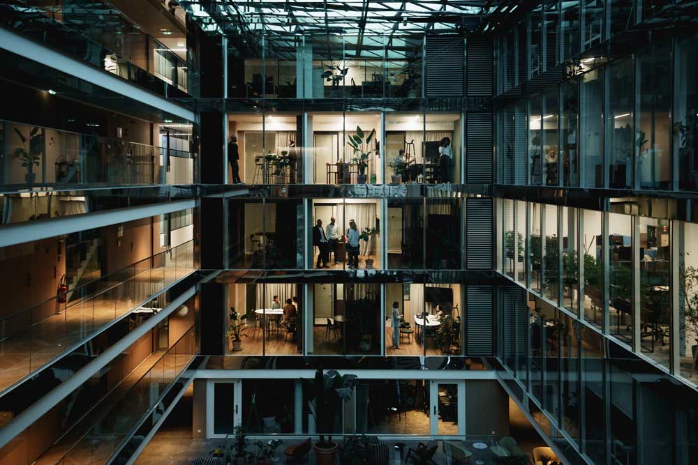En modern kontorsbyggnad i Paris fotograferad vid nattetid, som visar flera våningsplan med glasfasad och upplysta arbetsytor