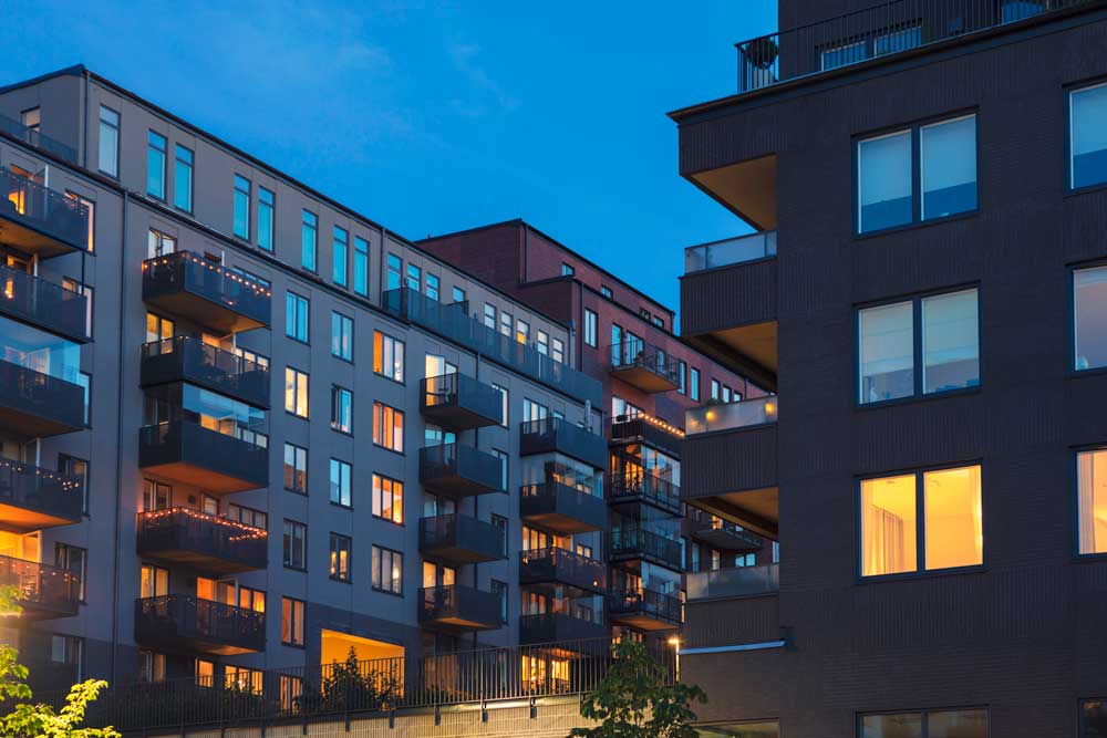 En vacker kvällsbild från Hammarby Sjöstad i Stockholm visar moderna lägenhetshus med karakteristisk skandinavisk arkitektur